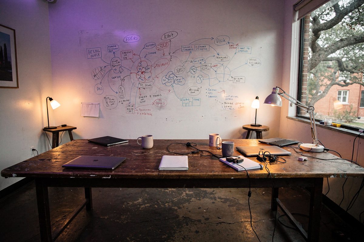 The main room of the Zervuqo studio with a whiteboard wall and a long table