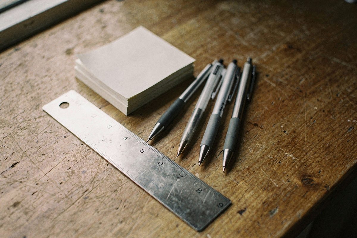 Pens, a ruler and sticky notes on the studio table